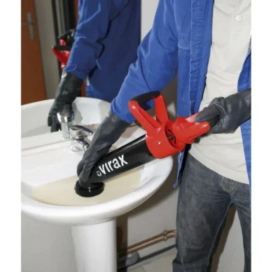 Une personne utilise un déboucheur pour nettoyer un évier.